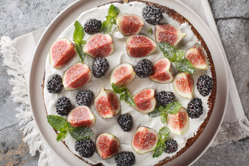 Autumn cake with figs, blackberries and ricotta cheese close-up in a plate on the table. Horizontal top view from above