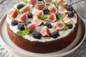 Delicious fig and blackberry cake with whipped cream close-up in a plate on the table. Horizontal