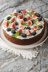 Italian fig and blackberry cake with cream cheese close-up in a plate on the table. Vertical