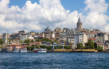Obraz premium Istanbul, Turkey - August 10, 2024: Panoramic view of Galata Tower and ancient architecture in the historic part of the city on the shores of the Sea of ​​Marmara and tourist boats on a sunny summer