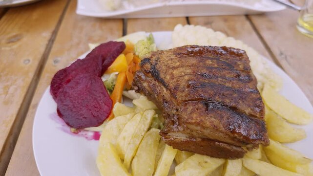 video 4K de comida peruana, lech&oacute;n a la caja china con choclo, ensalada y papas fritas