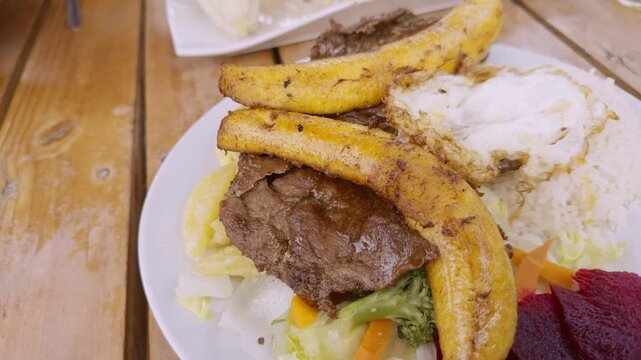 Video 4K de comida peruana, delicioso bistec a lo pobre 