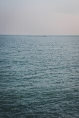 Obraz premium Looking out over the calm sea on a misty day.