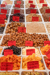 Italian market stall with variety of nuts, dried fruits and seeds for sale, price tags in Euro