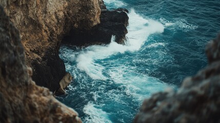 A stunning cliffside view of the ocean with waves crashing against the rocks, offering space for text above. Perfect for coastal, travel, or adventure themes.