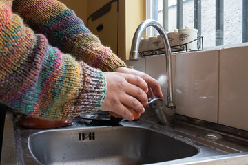 latino man drinks water in the sink