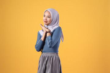 happy asian indonesian muslim women with hope hand gesture on isolated yellow background