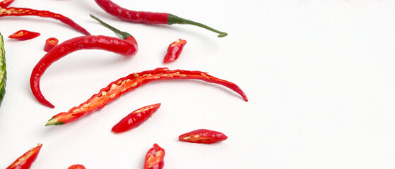 A group of fresh, vibrant red chili peppers with a distinctive curly shape, isolated on a white background with plenty of copy space for your text.