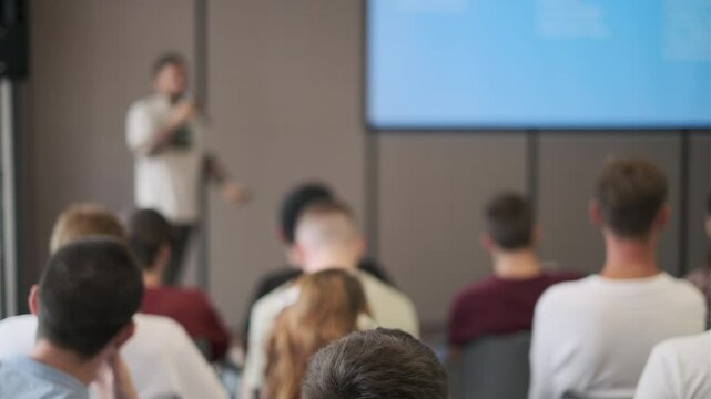 Speaker presents in front of a focused audience during a seminar. The setting is professional and conducive to learning and engagement.
