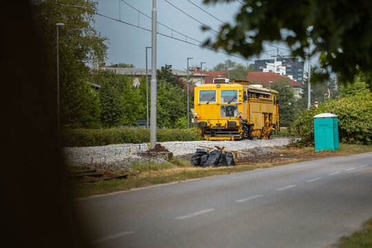 Heavy machinery on a railway tack that is under renovation. Fresh track laid and machines used to level the rails and align the gravel track bed. Ballast tamper in action