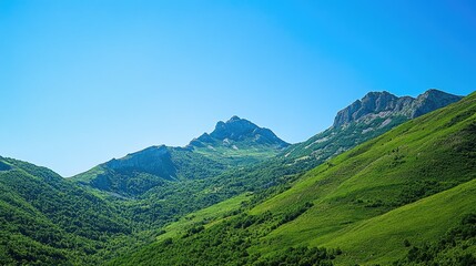 Obraz premium Lush green mountain slopes under a clear blue sky, abundant copy space.