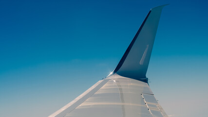 wing of the flying plane on a background of blue sky