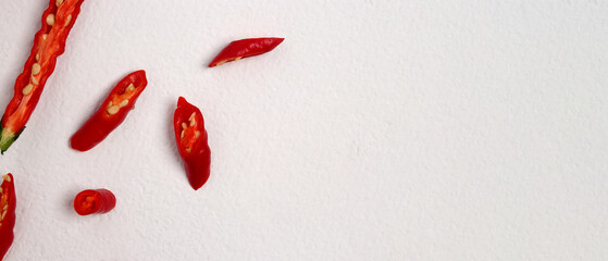 A group of fresh, vibrant red chili peppers with a distinctive curly shape, isolated on a white background with plenty of copy space for your text.