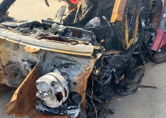 Burned-out car. Burned out new car in the city street. Burning car. Fire of a white passenger car