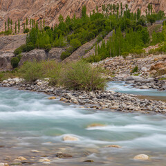 A smooth long exposure landscape of water in Indus River flowing in Leh, Ladakh India.