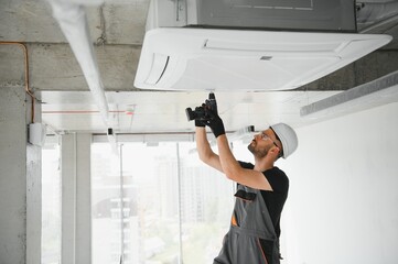 technician cleans air conditioner system in a modern apartment