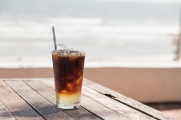 Refreshing iced coffee against a scenic beach backdrop, perfect for summer vibes and relaxation.
