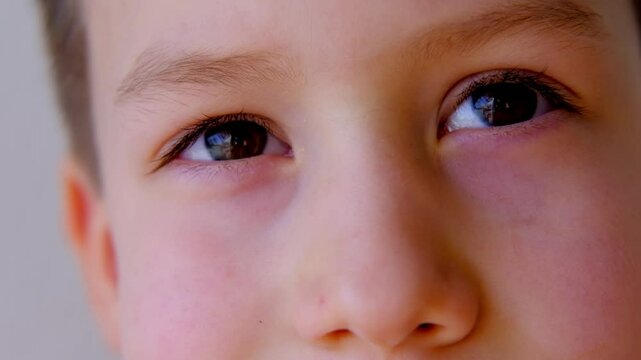 close-up of part of the child's face, boy 8-10 years old Asian-European appearance, human eye looking fun at the camera, the concept of surveillance, peeping, tracking
