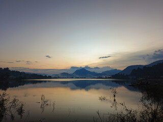 Fototapeta premium reflection of the evening sunset on a beautiful lake background with a blue orange sky