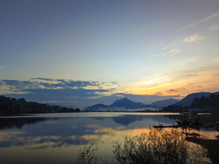Fototapeta premium reflection of the evening sunset on a beautiful lake background with a blue orange sky