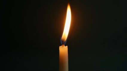 Single Burning Candle in Darkness