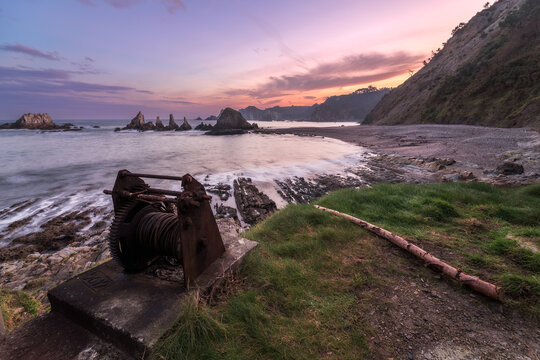 Serene sunrise at Gueirua Beach, Asturias with old winch