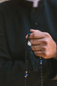 Close-up of a catholic priest holding rosary beads