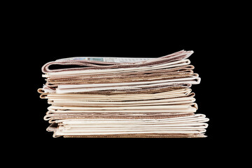 a stack of newspapers isolated on black background