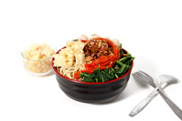 A bowl of Mie Ayam, a typical Indonesian dish, featuring chicken noodles with shredded chicken, meatballs, dumplings, green vegetables, and a variety of toppings, isolated on a white background