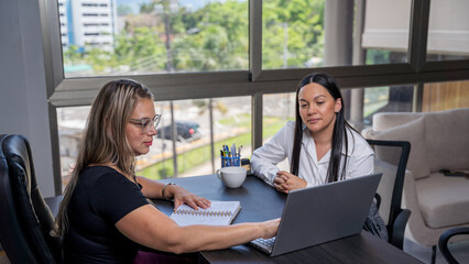 Two Latin Hispanic female lawyers working with a laptop
