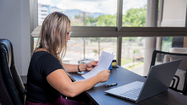 Hispanic lawyer reviewing documents in an office setting