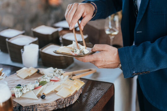 Elegant wedding buffet with variety of cheeses on wooden plate