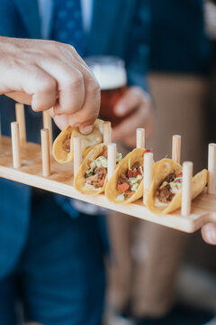 Man serves mini tacos at a stylish wedding event