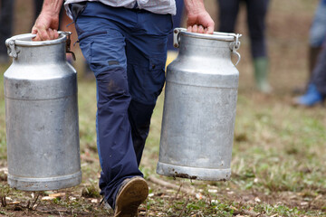 A man carrying two milk pots in a rural sports competition
