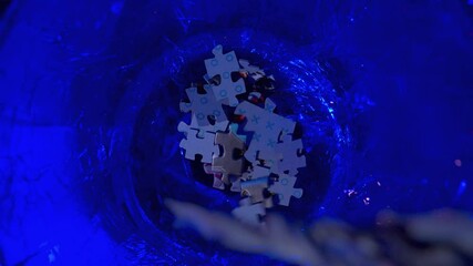 Scattered puzzle pieces in a dark blue setting, symbolizing complexity and challenge