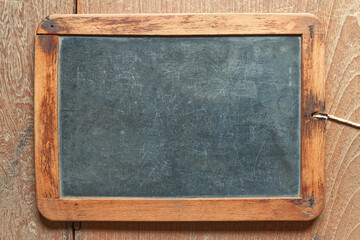 Very old writing slate on the wooden desk, ancient pad for students in the old days