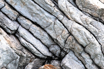 Rock stone wall close up with layers of rock formation texture. Natural wallpaper. Cliff. Pattern. 