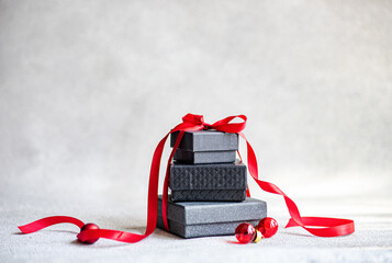 Christmas gift boxes with red ribbon on gray background
