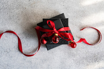 Holiday gift wrapped in elegant black with red ribbon