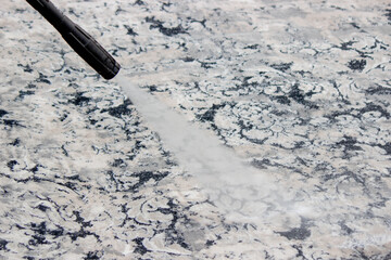 washing the carpet with a high pressure washer. Selective focus