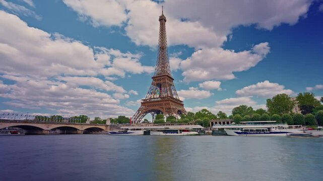 Timelapse of the Eiffel Tower along the river Seine with flyboats passing by with motion blur. Sunny but cloudy spring summer day paris city famous riverside bay tower view bridge time lapse panorama