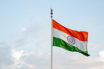The Indian flag fluttering gracefully against the backdrop of a stunning sky
