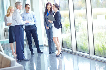 People, meeting and talk in lobby for business, introduction and office walkthrough. Receptionist,...