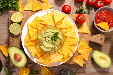 corn tortilla nachos chips with guacamole and spicey chili sauce