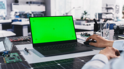 Anonymous Engineer Working in Lab on a Laptop Computer with Mock Up Green Screen Chromakey Display...