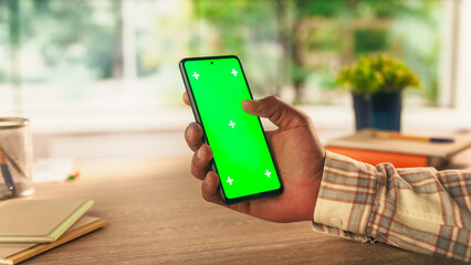 Anonymous Man Holding a Smartphone Device, Reading Articles on Mobile Phone with Green Screen Mock Up Display. Photo Template with Placeholder for Digital Marketing and Business Promotions