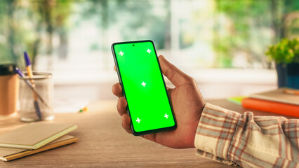 Anonymous Black Person Using a Smartphone with Mock Up Green Screen Chromakey Display with Motion Tracker Placeholders. Manager Browsing an App User Interface Online, Swiping and Tapping on the Phone