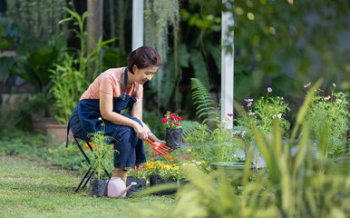 Senior asian woman gardening in frontyard. Life after retirement concept.