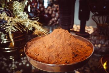 Cocoa powder in a metal cup on a rustic table