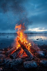 A cozy campfire crackles at dusk beside a tranquil lake, surrounded by stones under a cloudy sky in early evening hours